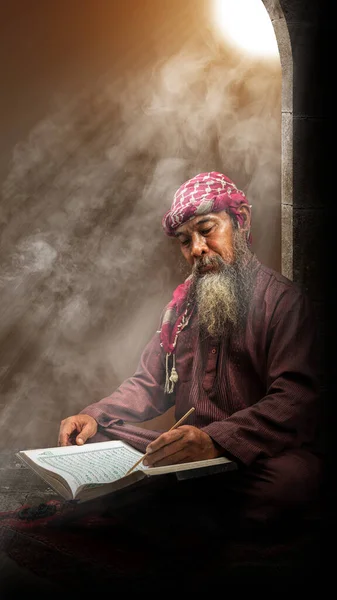 穆斯林男子 留着胡子 头戴头巾 坐着诵读 古兰经 躺在清真寺里的祈祷地毯上 — 图库照片