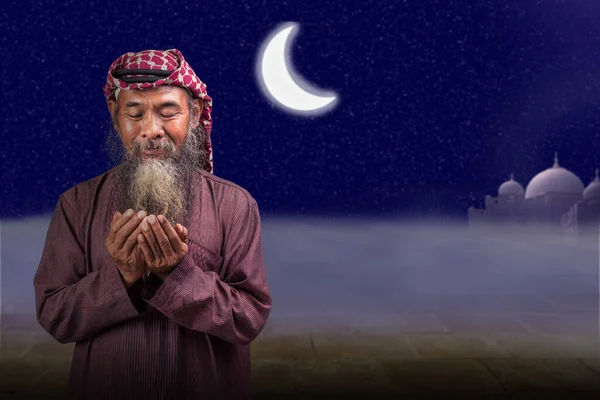 穆斯林男子 留着胡子 头戴头巾 头戴头巾 双手高举 手扶着夜景背景 — 图库照片