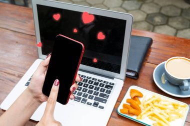 Sevgi simgeleriyle cep telefonu kullanan bir kadın. Sosyal medya günü kavramı