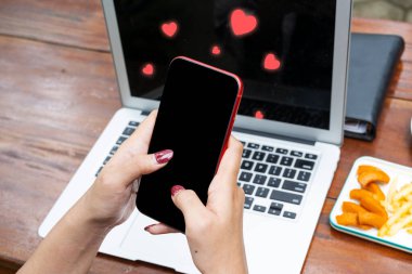Sevgi simgeleriyle cep telefonu kullanan bir kadın. Sosyal medya günü kavramı