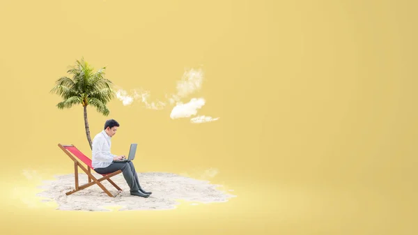 ビーチチェアに座っているアジアのビジネスマンは 色の背景にラップトップを使用しています — ストック写真