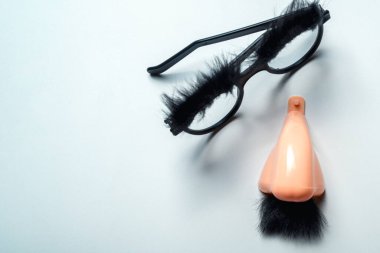 Beyaz arka planda burun ve bıyıklı gözlük.