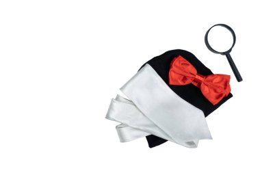 Siyah şapka, büyüteç ve beyaz arka planda izole edilmiş gümüş kravatlı kırmızı papyon.
