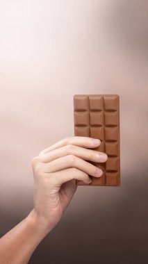 Çikolatayı tutan insan eli. Dünya Çikolata Günü konsepti