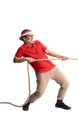 Indonesian men celebrate Indonesian independence day on 17 August with the tug of war contest isolated over white background