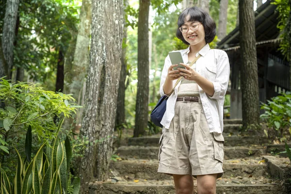 Ormanda Yürürken Cep Telefonu Kullanan Asyalı Bir Kadın Seyahat Etkinliği — Stok fotoğraf