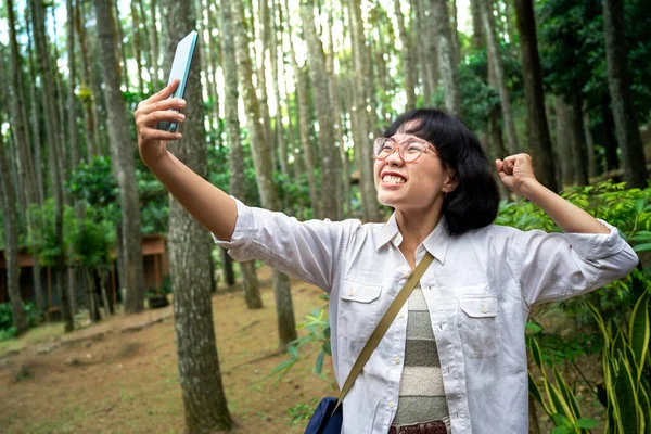 森の中で携帯電話を使って自画像を撮るアジアの女性 旅行活動 — ストック写真