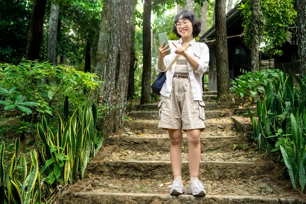 Azjatka Korzystająca Telefonu Komórkowego Podczas Spaceru Lesie Działalność Podróżnicza — Zdjęcie stockowe
