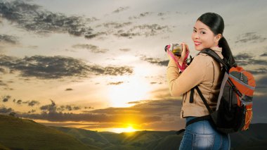 Asian woman with a backpack holding the camera. World Photography Day
