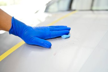 Man polishing car body in the garage