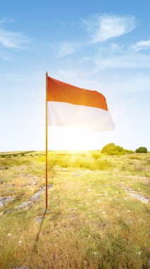 The red and white flag of Indonesian flag with the sunset scene background