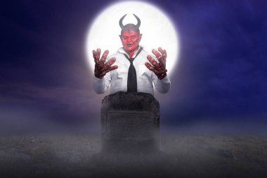 Devilman mezarlıkta duruyor ve gece sahnesi geçmişi var. Korkunç iblis Cadılar Bayramı konsepti