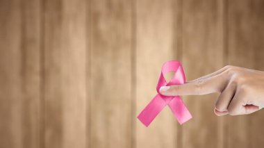 İnsan eli pembe farkındalık kurdelesi gösteriyor. Göğüs kanseri farkındalığı konsepti