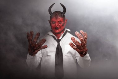 Şeytanadam karanlık arka planda duruyor. Korkunç iblis Cadılar Bayramı konsepti