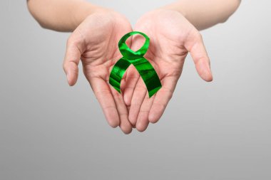 İnsan eli yeşil kurdele gösteriyor. Dünya Ruh Sağlığı Günü konsepti