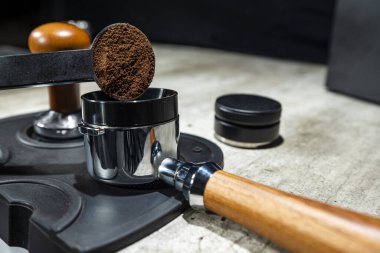 Barista 'nın eli iskele tarafındaki filtreye taze kahve döküyor. Espresso yap.
