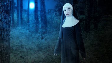 Gecenin bir yarısı sisli ormanda duran korkunç şeytan rahibe. Cadılar Bayramı için korkunç bir kadın. Cadılar Bayramı konsepti