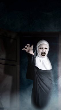 Karanlık bir arka planda, açık bir kapının üzerinde duran korkunç bir rahibe. Korkunç bir kadın. Cadılar Bayramı konsepti