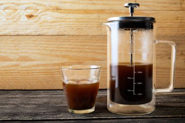 Masada bir fincan kahve ve kahve makinesi var.