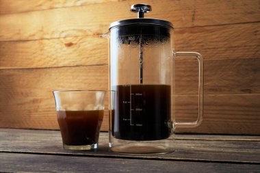 Masada bir fincan kahve ve kahve makinesi var.