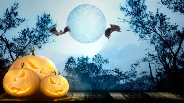Jack-o-Lantern on the wooden floor with flying bats on the misty forest with a full moon background. Halloween Wallpaper concept