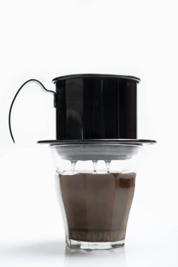 Beyaz arka planda izole edilmiş Vietnam damlalı kahve makinesi olan bir fincan kahve.