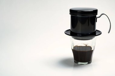 Beyaz arka planda izole edilmiş Vietnam damlalı kahve makinesi olan bir fincan kahve.