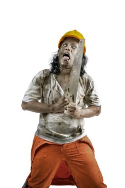 Vücudunda kan ve yaralar olan korkunç bir inşaat işçisi beyaz bir arka planda testere taşırken yürüyor.