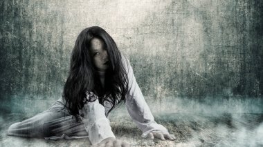 Korkunç bir hayalet kadın, arka planda grunge bir duvarla yerde sürünüyor. Korkunç bir kadın. Cadılar Bayramı konsepti