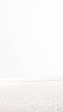 Beyaz gökyüzü arka planına sahip kum tepeciklerinin manzarası. Beyaz renk arkaplanı