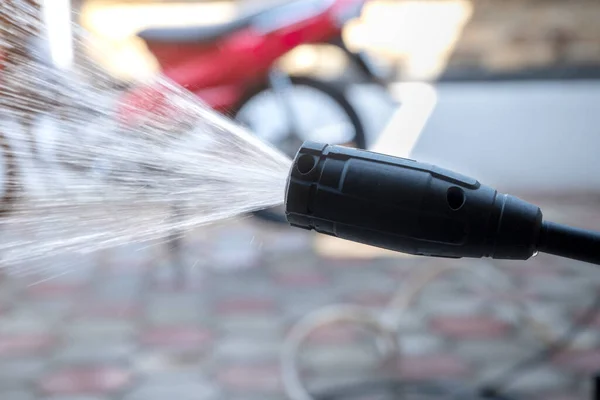 Washing the motorcycle with high-pressure water in the garage