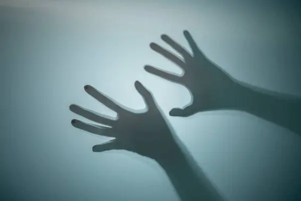 Shadow of a zombie's hand on a colored background. Scary Halloween concept