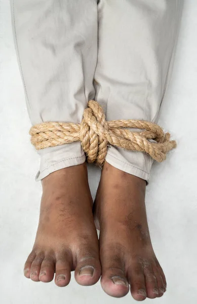 The man\'s legs are tied by rope. Violence concept