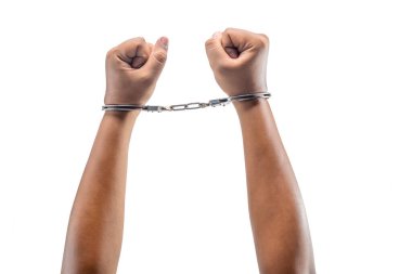 Elinde kelepçe olan tutuklu bir adam beyaz bir arka planda izole edilmiş.