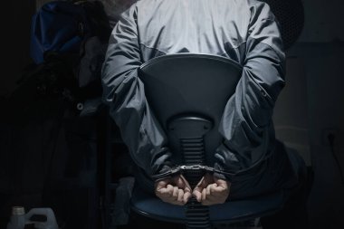 Adam elleri kelepçeli bir sandalyede oturuyordu. Şiddet kavramı