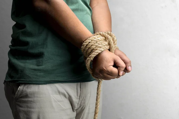 The man's hands are tied by rope. Violence concept