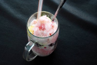 Dopingli. Endonezya 'dan geleneksel meyve buzu rendelenmiş hindistan cevizi, tapai, siyah yapışkan pirinç ve süt. Endonezya sokak yemekleri