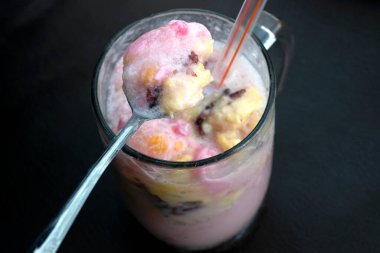 Dopingli. Endonezya 'dan geleneksel meyve buzu rendelenmiş hindistan cevizi, tapai, siyah yapışkan pirinç ve süt. Endonezya sokak yemekleri