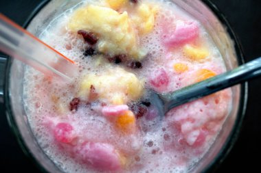 Dopingli. Endonezya 'dan geleneksel meyve buzu rendelenmiş hindistan cevizi, tapai, siyah yapışkan pirinç ve süt. Endonezya sokak yemekleri