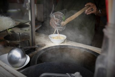 Garson servis için tavuklu erişte (Mie Ayam) hazırlıyor. Geleneksel Endonezya yemekleri