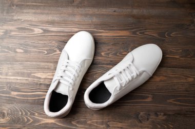 Ahşap arka planda temiz beyaz spor ayakkabılarının yakın görüntüsü