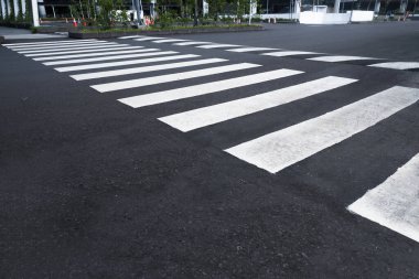 Yaya geçidi için siyah asfalt yolda beyaz şeritler. Karşıya geçmek için bir yer.