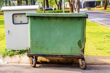 Parkta büyük yeşil çöp bidonları