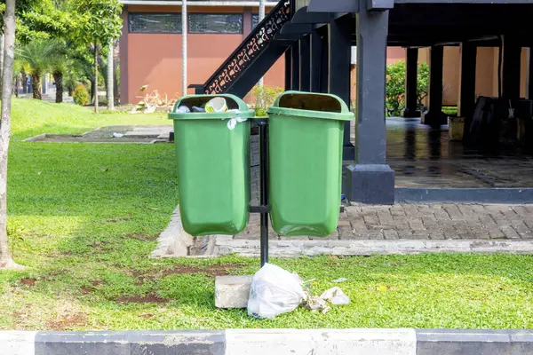 Green garbage bins hanging in the park