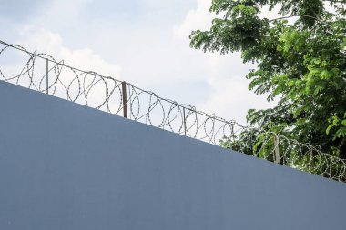 Dikenli tel örgülü duvar mavi gökyüzü arkaplanı