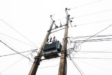 Mavi gökyüzü arka planına sahip yüksek voltajlı elektrik hatları kulesi