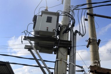 Mavi gökyüzü arka planına sahip yüksek voltajlı elektrik hatları kulesi