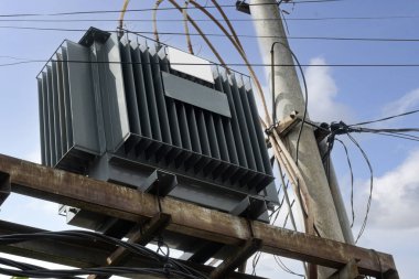 Mavi gökyüzü arka planına sahip yüksek voltajlı elektrik hatları kulesi