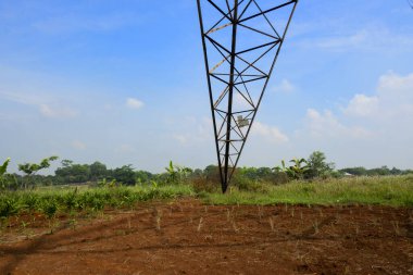 Mavi gökyüzü arka planına sahip yüksek voltajlı elektrik hatları kulesi