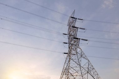 Günbatımı sahnesi olan yüksek voltajlı elektrik hatları kulesi.